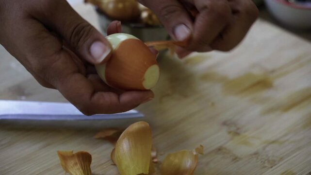 Close up shot of hands peeling an onion, interior