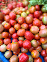 Tomato in the market. A pile of red cherry tomatoes sold in traditional markets is the main ingredient in all Indonesian. fresh tomatoes for sale at Grocery store. Colorful shiny fresh vegetables