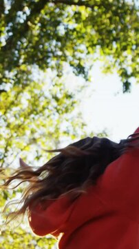 Girl outdoors turning and holding up hands