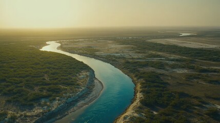 Aerial View Of River Winding Through Lush Landscape At Sunrise