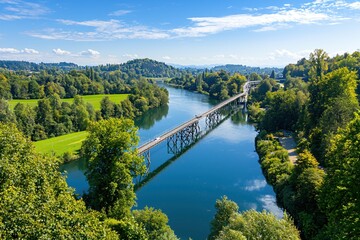 Fototapeta premium Scenic view of a bridge over a river surrounded by lush trees under a bright blue sky