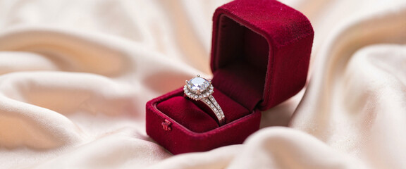 Elegant diamond engagement rings in velvet box on silk fabric, love symbol