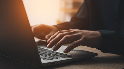 Closeup of businessman hand typing on laptop computer at office.  Business man working on computer device