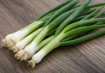 Obraz premium A bunch of green onions with roots, elegantly arranged on a wooden table, emphasizing freshness and quality, perfect for food styling.