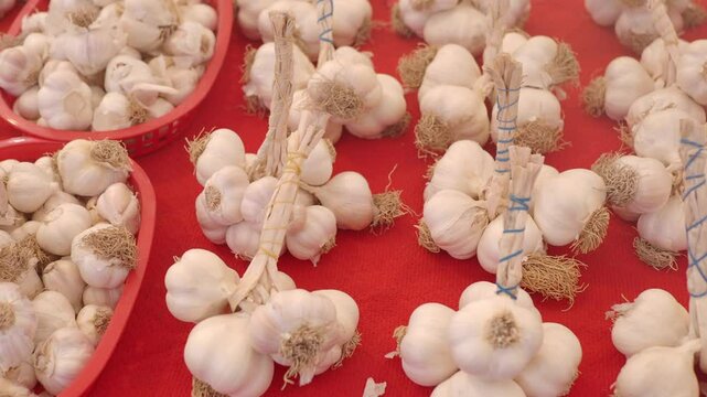 Fresh garlic strings displayed at farmers market for sale