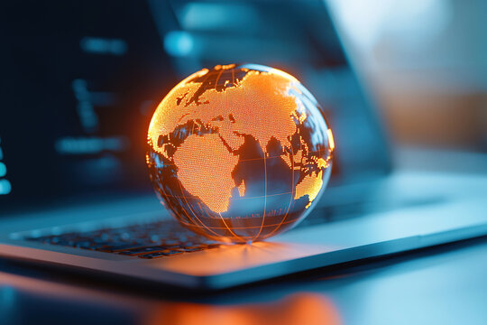 glowing digital globe sits laptop keyboard, symbolizing global connectivity and technology. vibrant orange hue of globe contrasts with sleek, modern design of laptop, highlighting innovation and