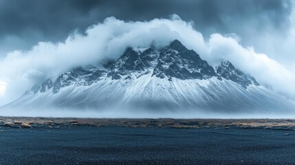 Snowy Mountain Range With Dramatic Clouds Over Black Sand Beach