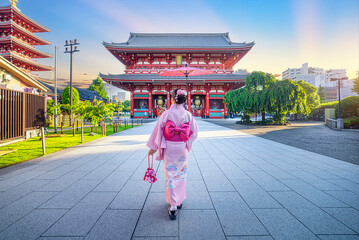 Asian woman in kimono walks at Asakusa Sensoji Temple, a landmark located in Kaminarimon in the Sensoji district. A famous temple in the morning in Tokyo, Japan.