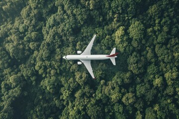 Airplane flying over dense green forest canopy during daylight, showcasing nature from above and aviation technology