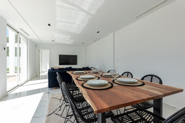 a close up image of a large wooden dining table with cutlery and plates in luxury mediterranean holiday home
