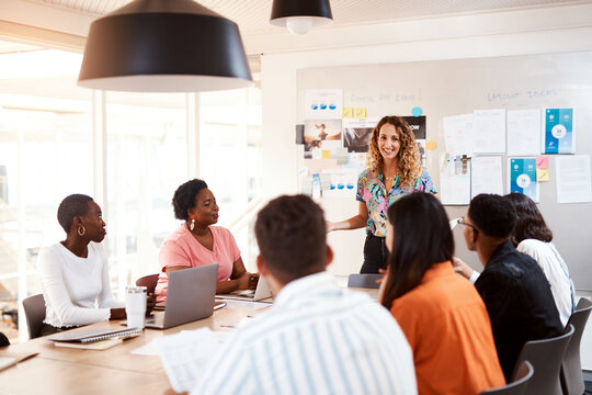 Business people, meeting and manager talking in office, graphic designers and team discussion. Employees, briefing and collaboration with colleagues in workplace, boardroom presentation and agency