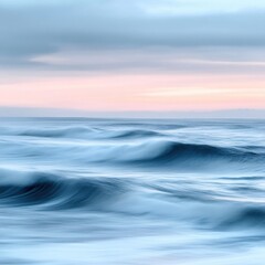 Fototapeta premium Gentle ocean waves roll under a soft pastel sky at sunset creating a peaceful scene