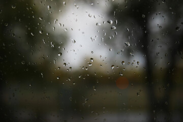 Rain Drops on Window Glass Focused Viewing Blurred Outdoor Landscape in Background