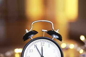 Vintage Black Alarm Clock with Light Bokeh Background Evoking Nostalgia and Time Concepts