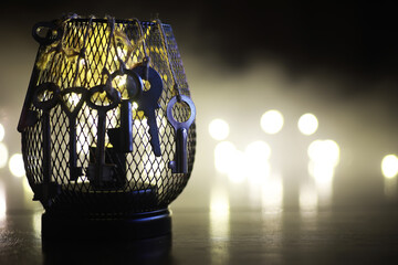 Vintage Metal Lantern with Hanging Keys Against a Glowing Bokeh Background