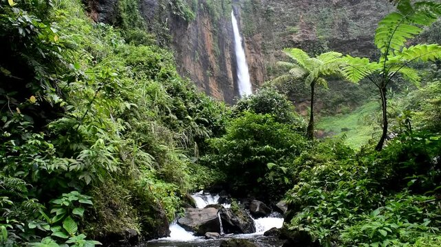 Kapas Biru waterfall seen from a distance, a waterfall from a 100 meters cliff originating from a spring at the foot of Mount Semeru.