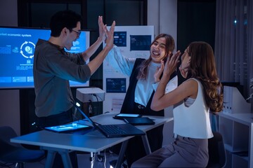 group of investor clapping hand to celebrating a successful outcome in a modern office  in front of a digital screen displaying financial data