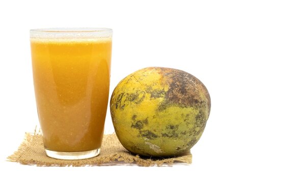 Ripe Indian Bael Fruit Sharbat or Juice in a Glass or Wood Apple Isolated on White Background with Copy Space, Also Known as Aegle Marmelos, Bengal Quince, Japanese Bitter Orange or Stone Apple22