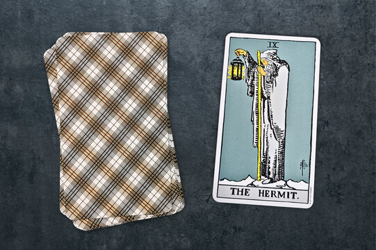La carte repr&eacute;sent&eacute;e est "L'Ermite" du jeu de tarot Rider-Waite. Elle symbolise l&rsquo;introspection, la sagesse et la qu&ecirc;te de v&eacute;rit&eacute;, avec un vieil homme portant une lanterne et un b&acirc;ton. Fond gris