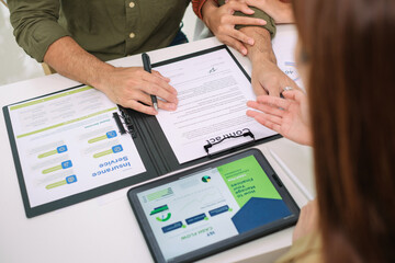 Asian couple reviewing and sign contract financial documents with the guidance of  advisor at...