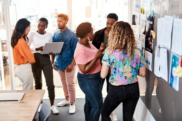 Fototapeta premium Creative, people and meeting in office with laptop, documents and planning fitness campaign. Design team, tech and paper in agency for marketing strategy, discussion and brainstorming sports business