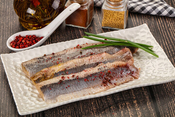 Salted marinated herring fillet with spices