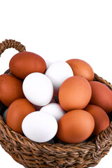 brown and white chicken eggs in a wicker basket on a white background
