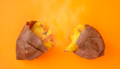 Baked sweet potato on the orange background and steam....