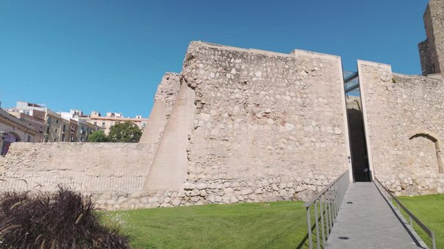 Ancient stone walls and entrance of The Monges Tower under clear blue skies in Tarragona Spain