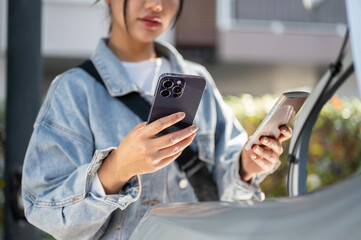 A close-up of a woman checks her passport, flight details on her phone before getting into a taxi.