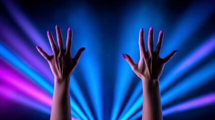 Two hands raised in the air against a backdrop of vibrant purple and blue spotlights, creating a dramatic and energetic atmosphere