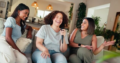 Women, friends and karaoke in home, happy and laughing on sofa with funny singing challenge in lounge. People, music and video game contest for voice performance, bonding and relax in living room
