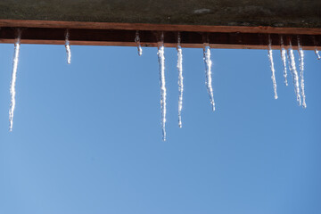 屋根の下に伸びる美しい氷柱
