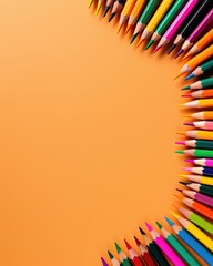 A vibrant array of colored pencils arranged in a semi-circle against a warm orange background, ideal for creative projects and artistic expression.