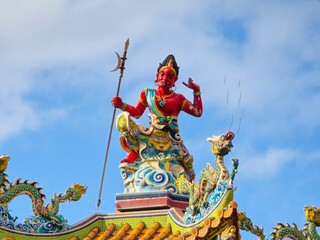 Red Qianliyan Statue on Temple Roof with Majestic Expression
