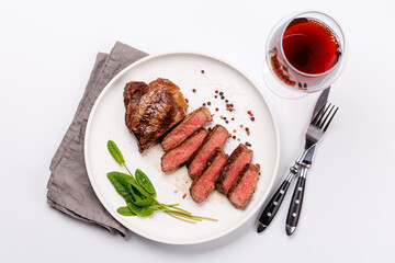 A perfectly cooked sliced striploin steak with a juicy, tender texture, served alongside a glass of rich red wine