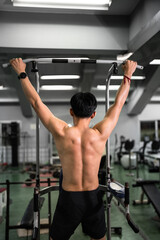 Fototapeta premium Asia Man's back with muscle in pull-up gym machine 