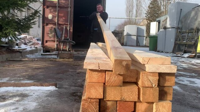 A worker checks the quality of wooden blocks.