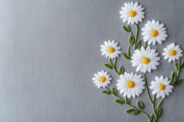 Obraz premium White Daisy Embroidery on Soft Grey Fabric Background