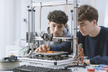 Students learning how to use a 3D printer in the lab