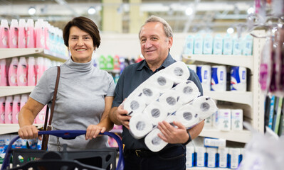 Elderly man and elderly woman choose toilet paper