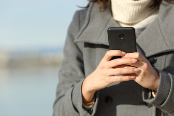 Closeup of a woman hand using phone in winter