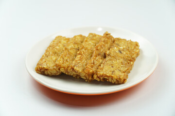 Plate of Fried Tempeh Slices, Indonesian Traditional Food Isolated on white background