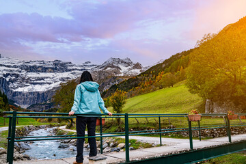 A serene moment in Gavarnie, France, featuring snow-capped peaks, lush green fields, a peaceful...