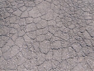 摩耗してひび割れた古い舗装路