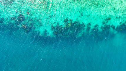 Top view, sandy beach background for summer vacation concept. Nature of beach and summer sea water with sunlight, sparkling sea water, coral reefs, underwater.	