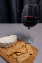 Enjoying cheese and crackers paired with red wine for a cozy evening relaxation