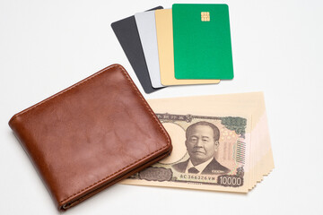 各種のクレジットカードと財布と一万円札