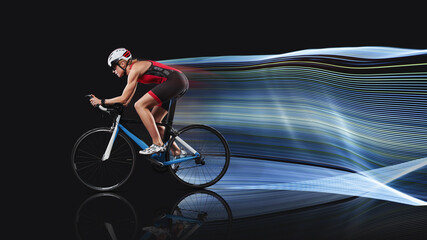 Cyclist in sportswear and sport helmet riding road bike isolated on black background. Concept of...