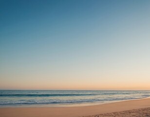 A serene beach scene at dusk with gentle waves lapping against the shore.